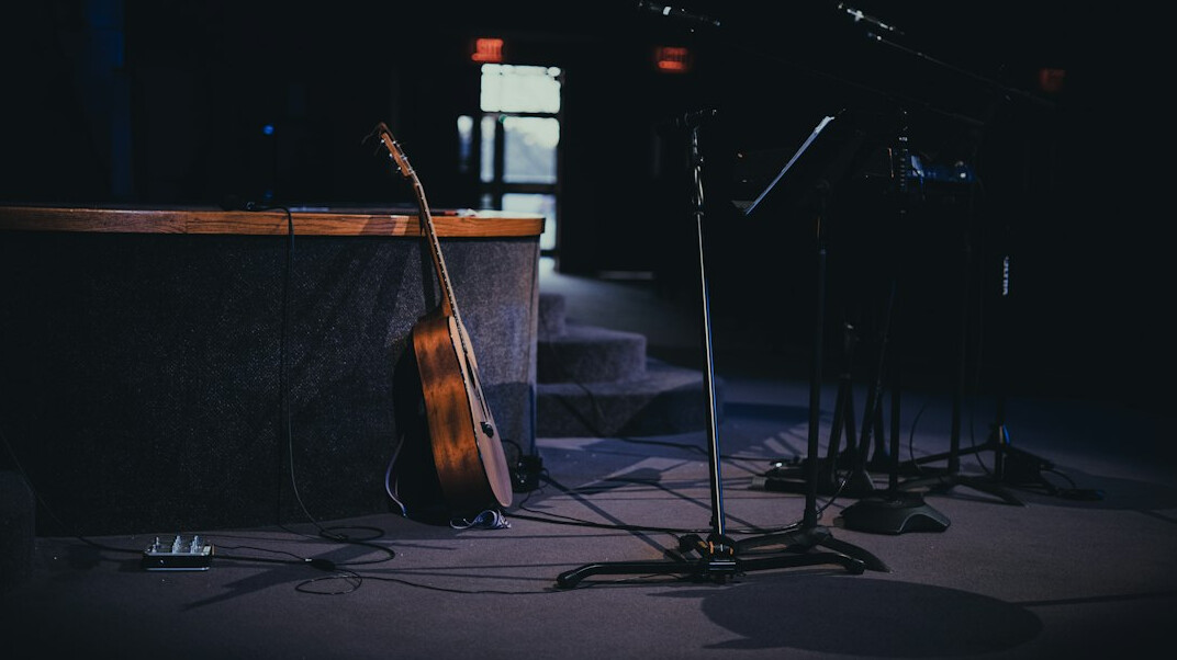 Empty stage with wooden podium and microphone under warm spotlight